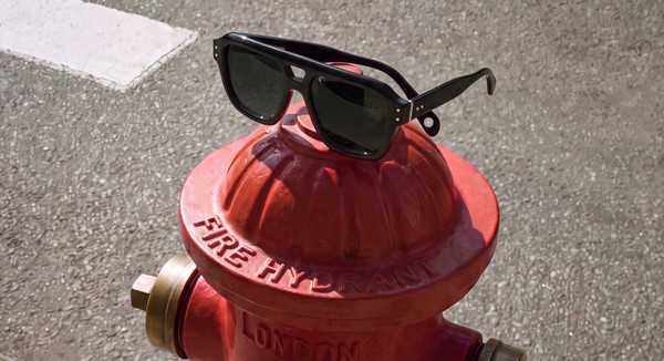 Black bloobloom sunglasses displayed on top of a red London fire hydrant.